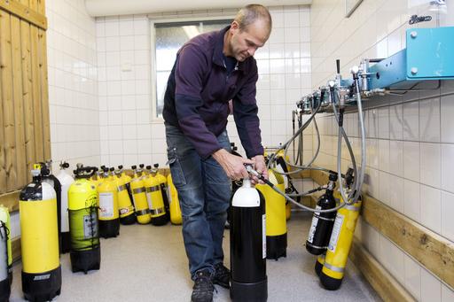 Man filling up air in diving cylinders