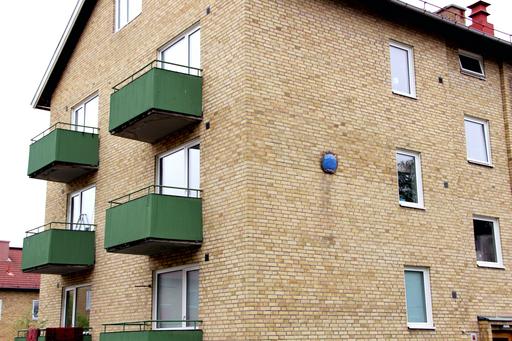 Fasad med gult tegel, lägenhetshus, foto.