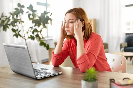 Bilden visar en kvinnas stressade arbetssituation vid hemarbete.