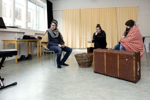 Tre teaterlärarstudenter i ett klassrum med kostym och rekvisita.