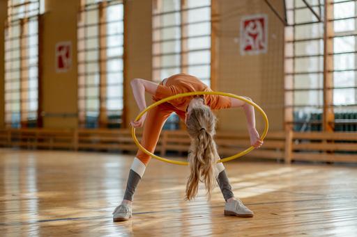 girl playing with hoop in gym hall