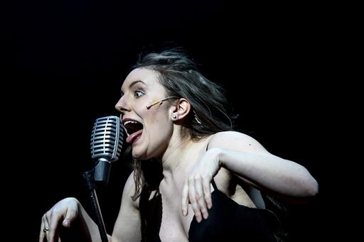 Musikalstudent grimaserar och sjunger i mikrofon