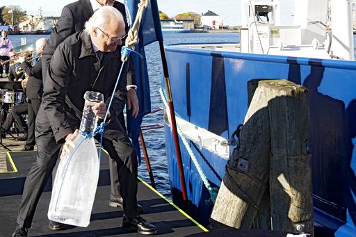 HM King Carl XVI Gustaf swings the ice bottle towards Skagerak's hull.