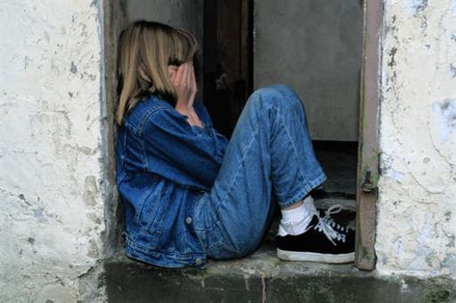 Sad young girl sitting on concrete steps