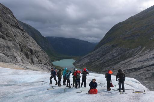 En grupp studenter står invid en glaciär i Norge