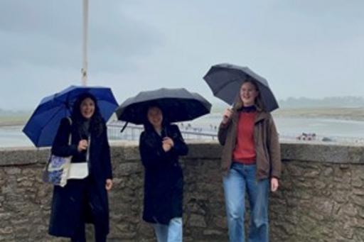 Studenter med paraply på strand i Normandie