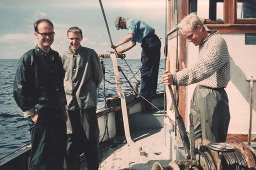 Tre män ombord på en båt.