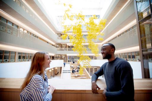 Två personer som står på en balkong i atriet