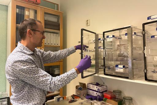 Man in front of glass cabinet