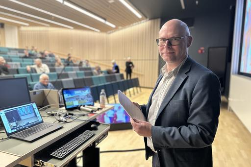 Bild på person med publik i bakgrunden.