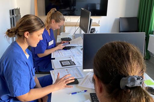 Studenter med formulär framför sig matar in i Forms på sina telefoner.