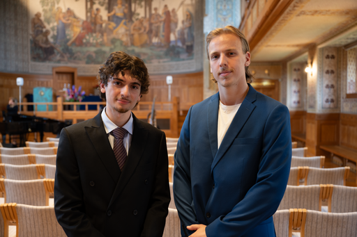 Två män i kavaj i universitetets aula