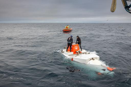 Rhian Waller står ovanpå en ubåt mitt ute i havet