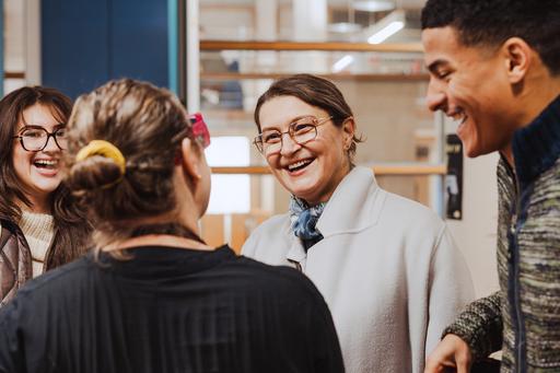 Fyra besökare på Öppet Hus pratar och skrattar.