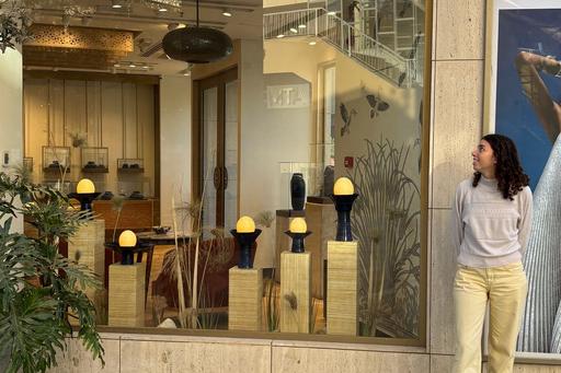 En kvinna står framför ett skyltfönster med lampor