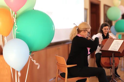 Två personer spelar fiol och cello på ett podium