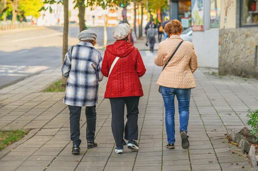 Tre äldre kvinnor gående bortåt på gatan