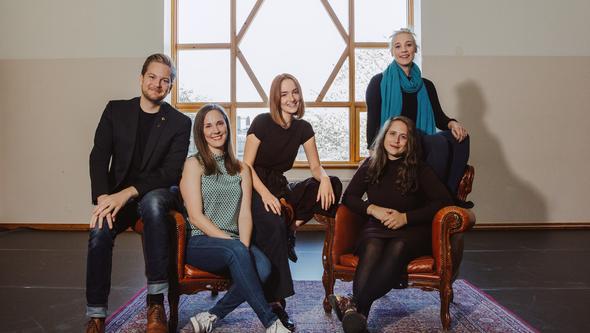 En grupp personer tittar in i kameran