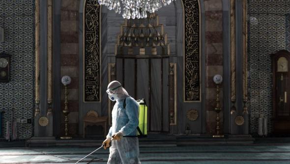 En kommunarbetare desinficerar en moské för att förhindra spridningen av SARS-CoV-2-viruset före fredagsbönen