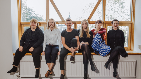 En grupp personer tittar in i kameran