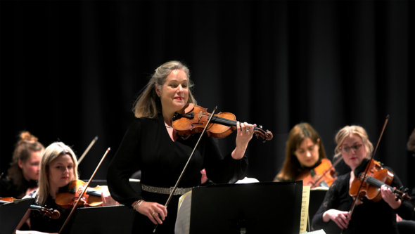 Isabelle van Keuelen, violin på scen med stråkstudenter i bakgrunden. Konsert på Kronhuset 31 oktober 2019.