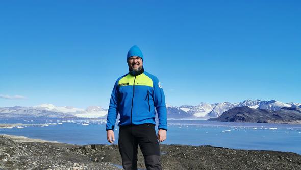 En man står i vinterkläder på Svalbard. 