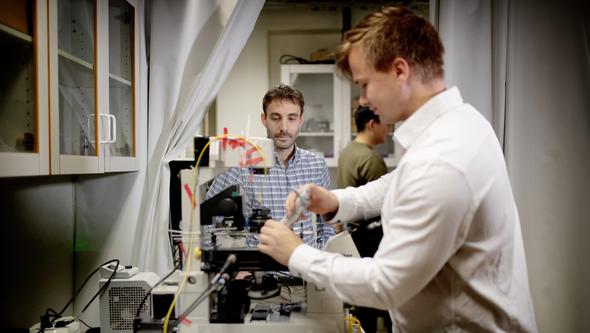 Två personer står i ett laboratorium. 