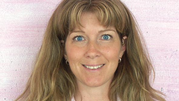 Porträttfoto av Elisabeth framför rosa vägg