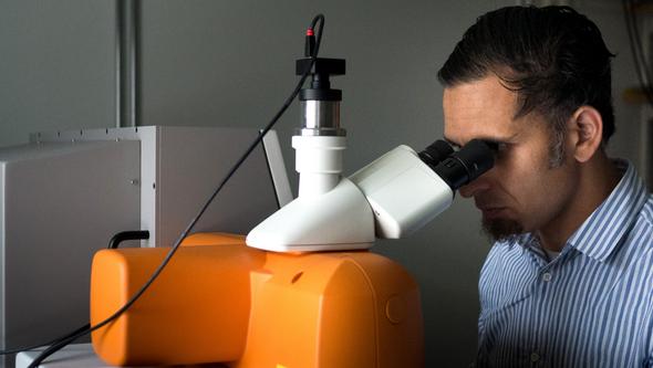 Furqan A. Shah at the Raman microscope, an instrument used to analyze the chemical composition of a material at the molecular le