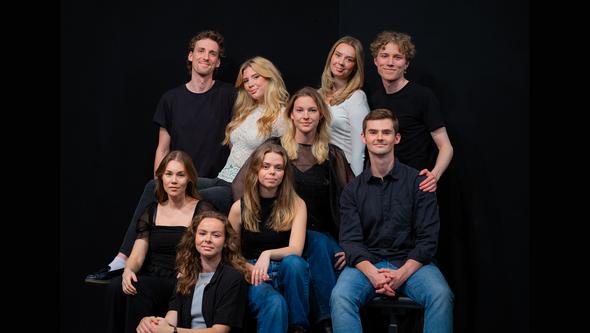 En grupp personer i ett svart rum