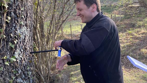 Picture of Jakub Truskowski while taking a tree sample.