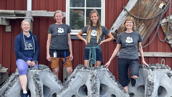 Fyra glada forskare står uppställda bakom stjärnformade betongklumpar.