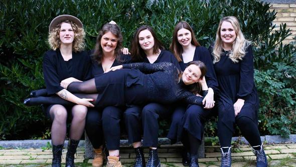 En grupp personer tittar in i kameran
