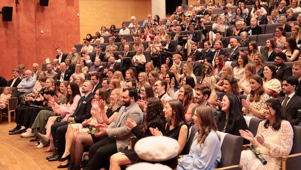 Foto av diplomander som skrattar och applåderar