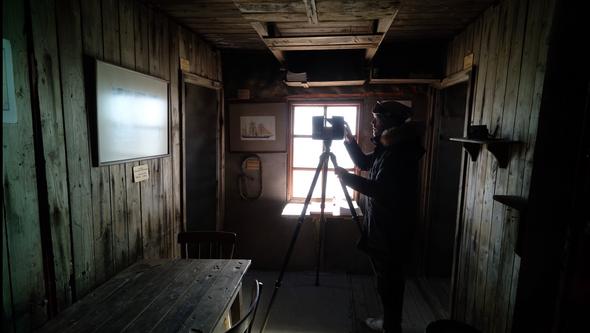 En man fotograferar Otto Nordenskjölds lämningar