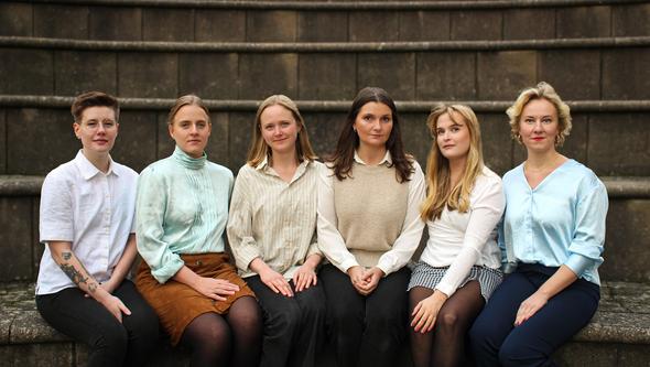 En grupp personer tittar in i kameran