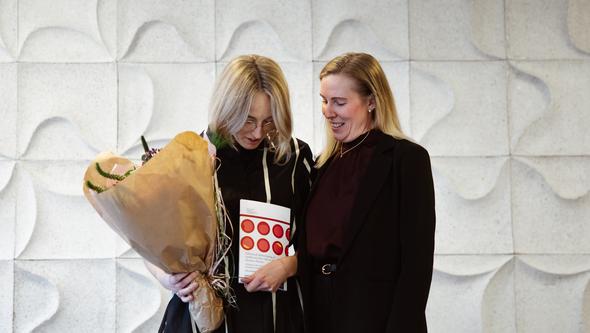 two happy women with flowers and the thesis
