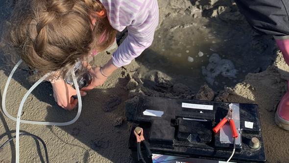 Car battery and a hole in the sand 