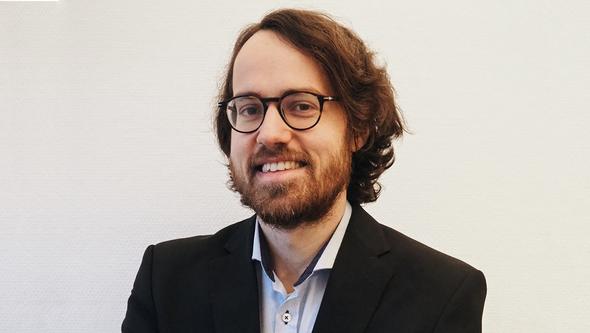 Markus Dertwinkel-Kalt infront of a white wall 