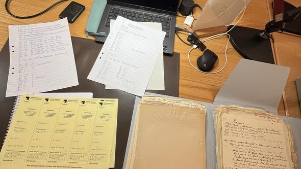 Bild på texter och papper i ett arkiv. 