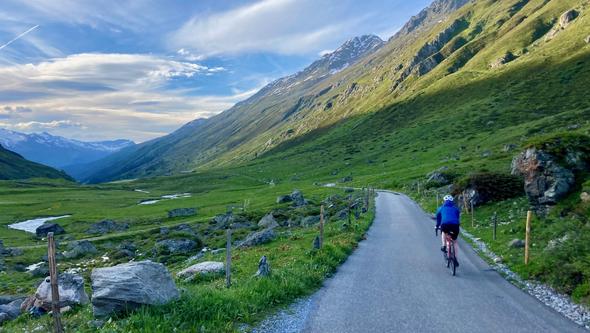 Cyclist on a road in the Swiss Alps