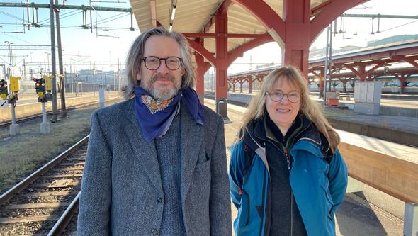 En man och en kvinna står på en tågperrong