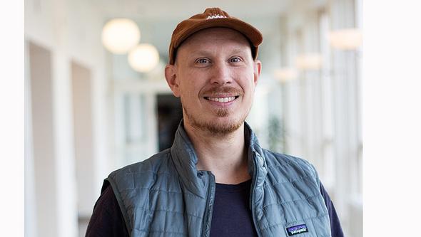 Jens i ljus korridor på Handelshögskolan. 