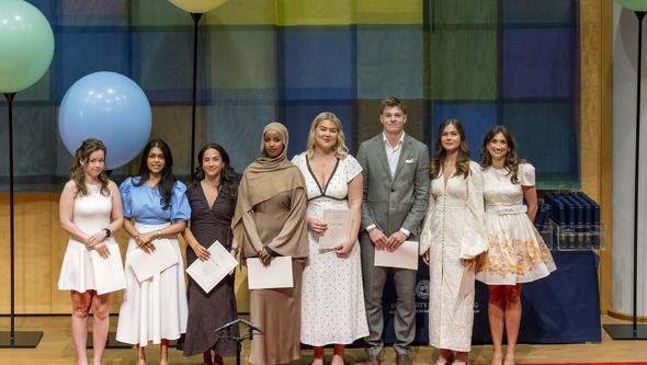 Studenter som fått pris står på en rad på scenen