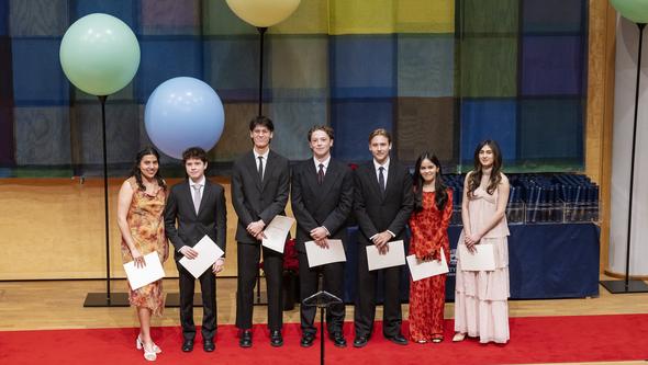 Studenter som fått pris står på en rad på scenen