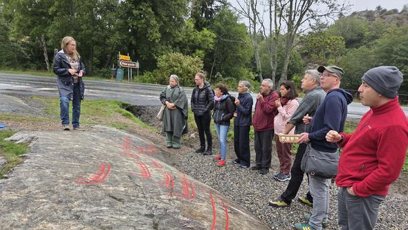 People watching rock carvings