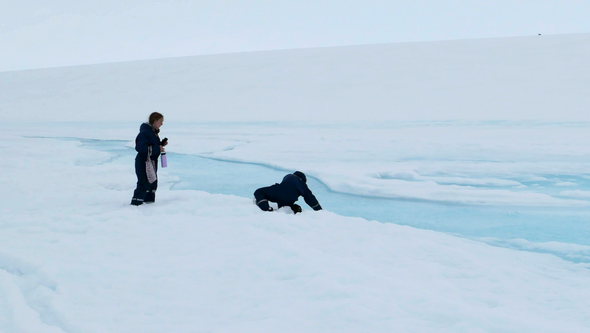 Researchers on a glacier sampling meltwater.