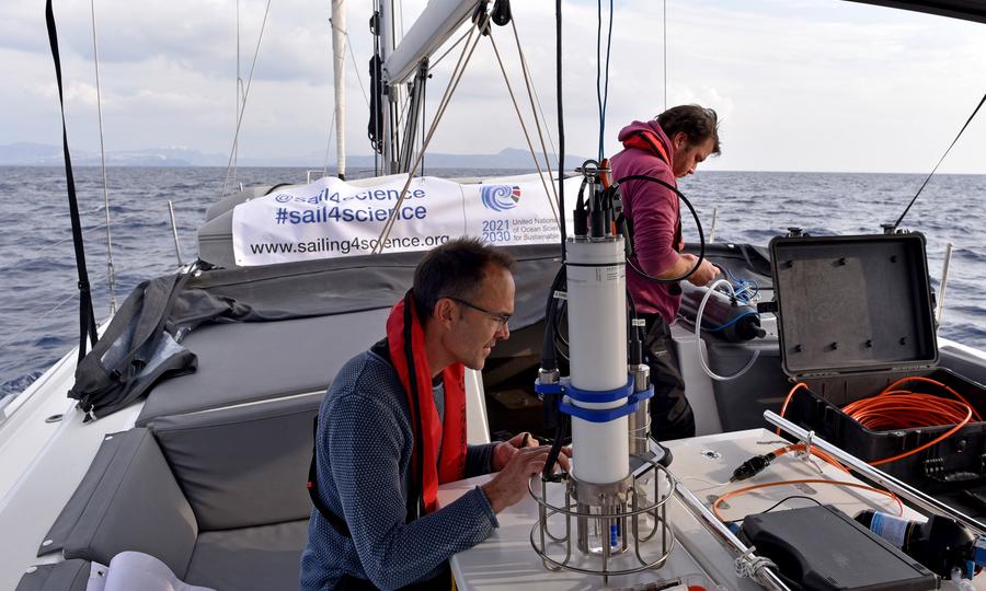 Man on sailingboat with measuring instrument