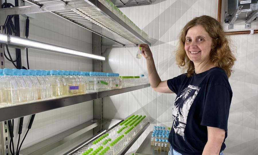 Olga håller upp en flaska med alger 
