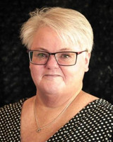 porträttbild av kvinna med glasögon och ljust hår i prickig tröja